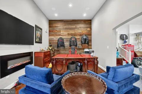 a living room with furniture a flat screen tv and kitchen view