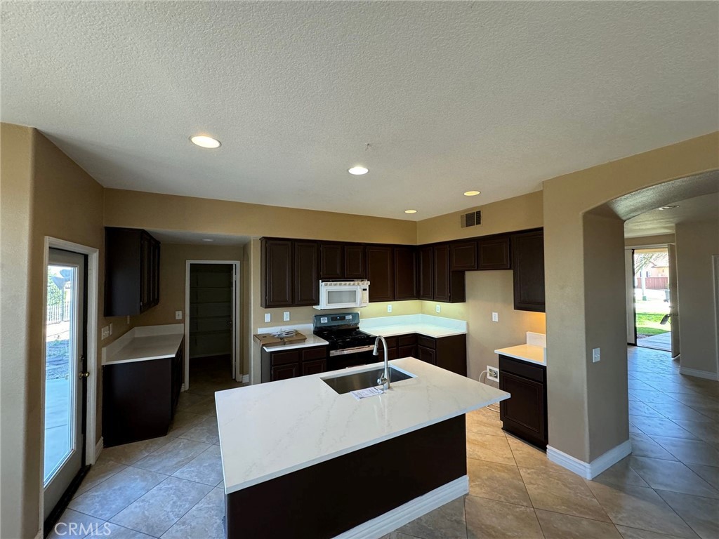 31970 Cercle Chambertin Temecula, CA 92591 - Photo 10 of 45 a kitchen with kitchen island a sink stainless steel appliances and cabinets