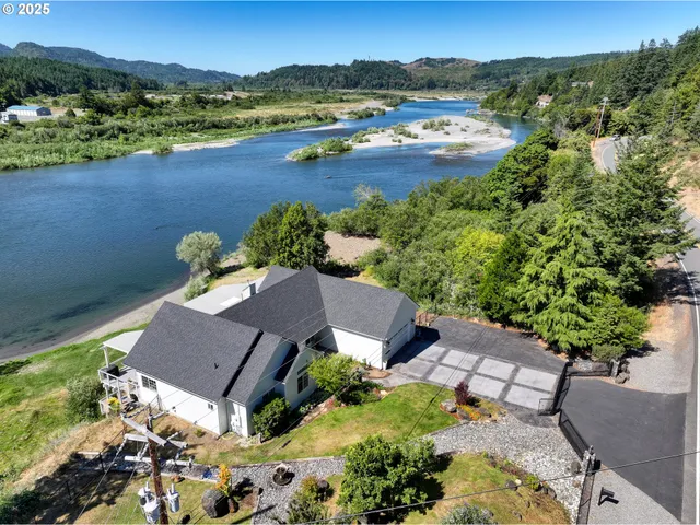 an aerial view of a house with garden space and lake view
