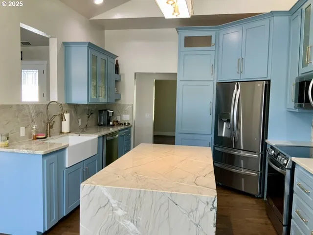 a kitchen with a refrigerator sink and cabinets