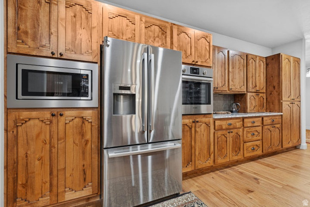 2925 Juniper Road Enterprise, UT 84725 - Photo 16 of 56 Kitchen with stainless steel appliances, wood finish cabinets, light wood-style floors, and tasteful backsplash