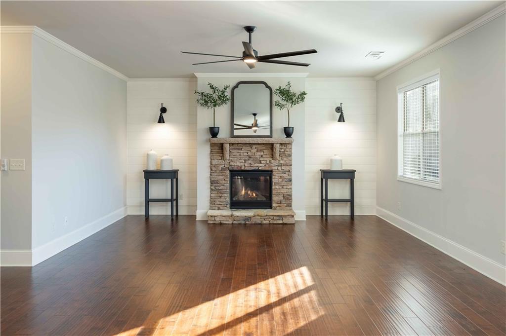 5875 Chestnut Drive Cumming, GA 30040 - Photo 15 of 55 a view of an empty room with wooden floor fireplace and a window