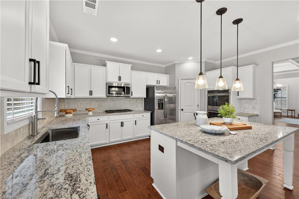 5875 Chestnut Drive Cumming, GA 30040 - Photo 20 of 55 a kitchen with stainless steel appliances granite countertop a stove refrigerator a sink a oven and microwave