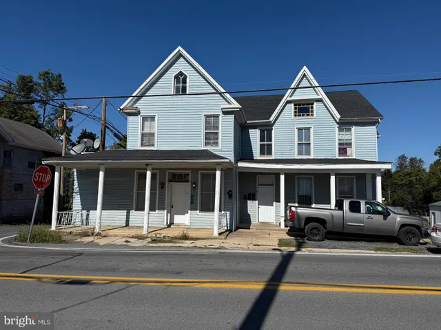 a view of a brick house with large windows and a road