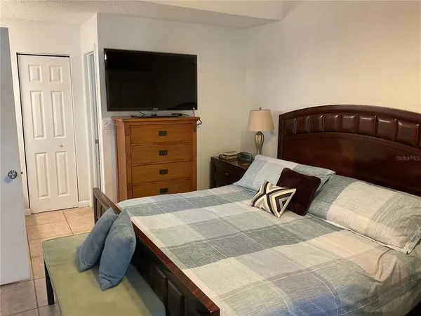 a bedroom with a bed and a flat screen tv