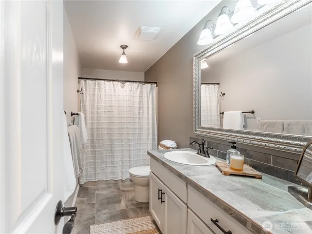 a bathroom with a sink a toilet and shower