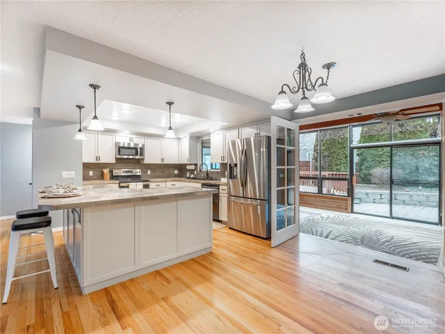 a kitchen with stainless steel appliances granite countertop a refrigerator and a stove top oven