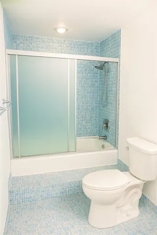 a bathroom with a toilet and a shower