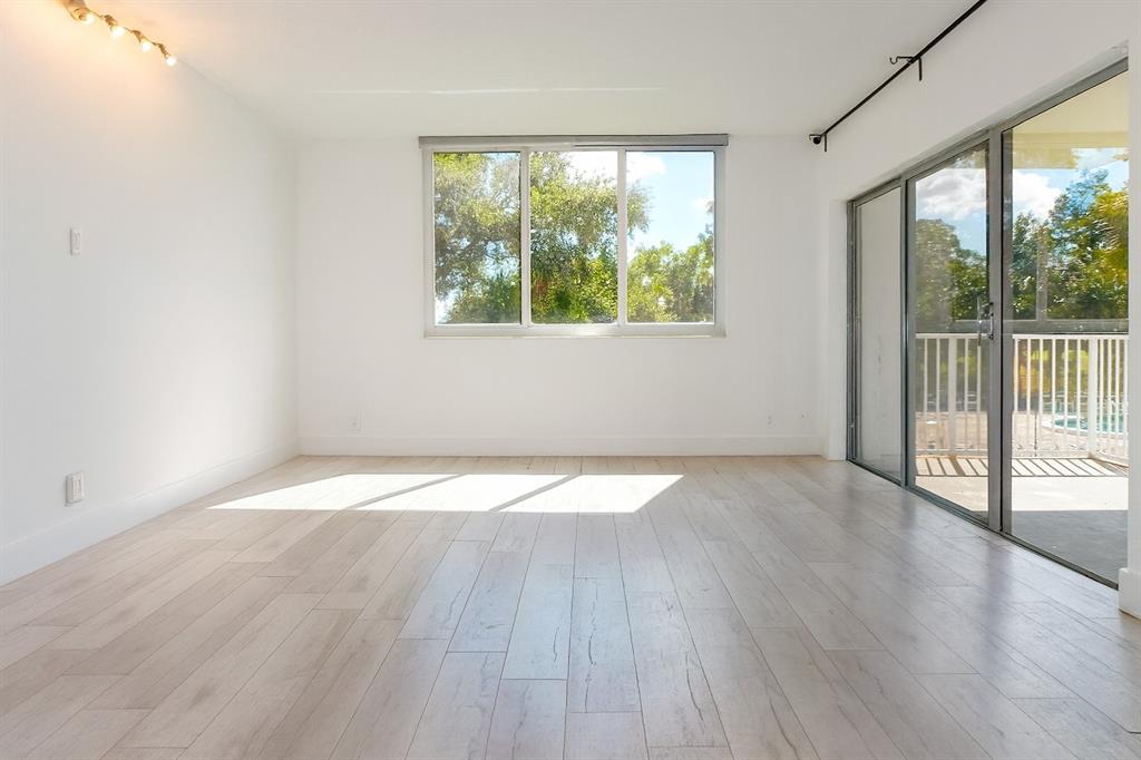 4200 Hillcrest Drive, Unit 201 Hollywood, FL 33021 - Photo 6 of 24 an empty room with wooden floor and windows
