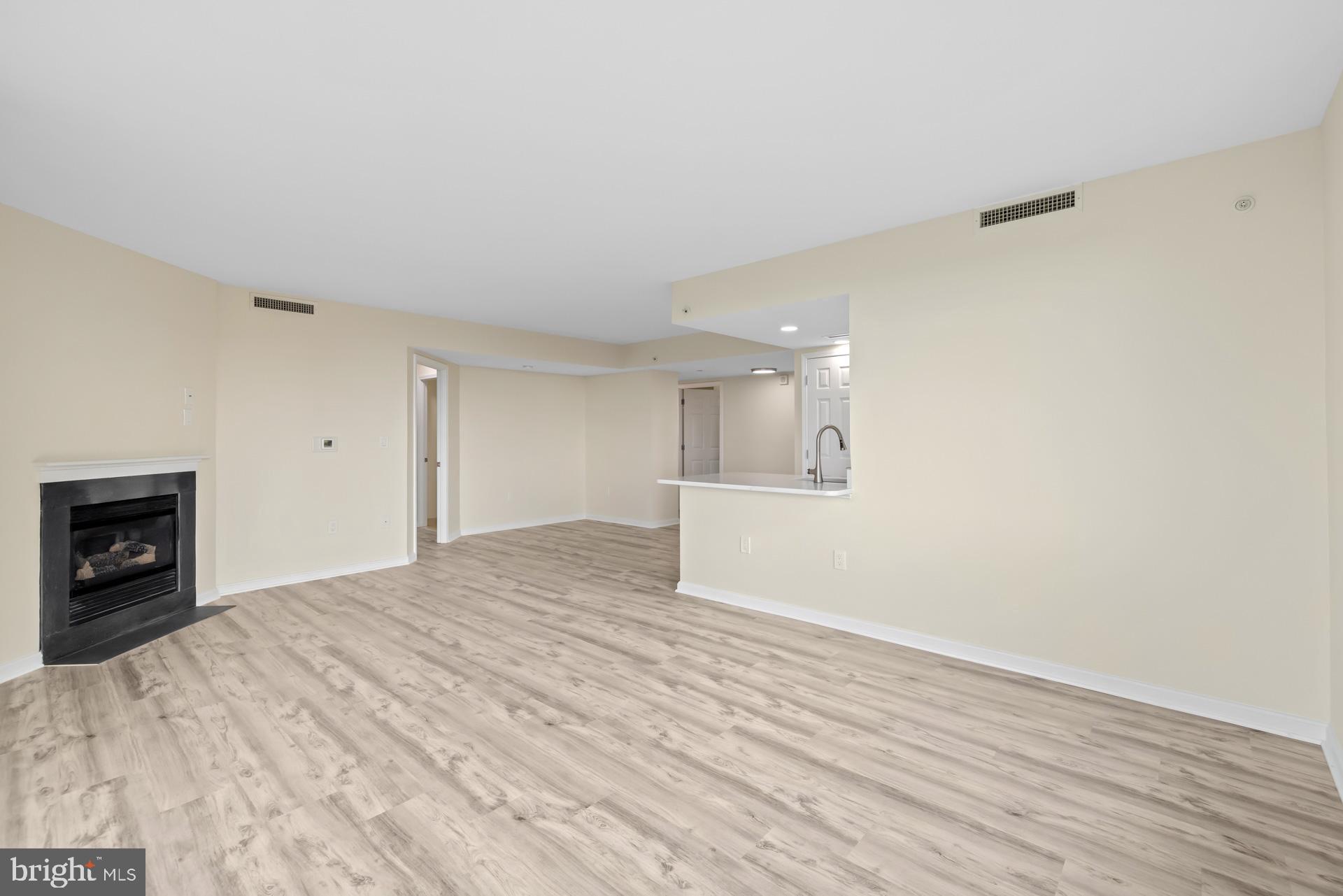 11710 Old Georgetown Road, Unit 1116W North Bethesda, MD 20852 - Photo 11 of 52 a view of empty room with a fireplace and wooden floor