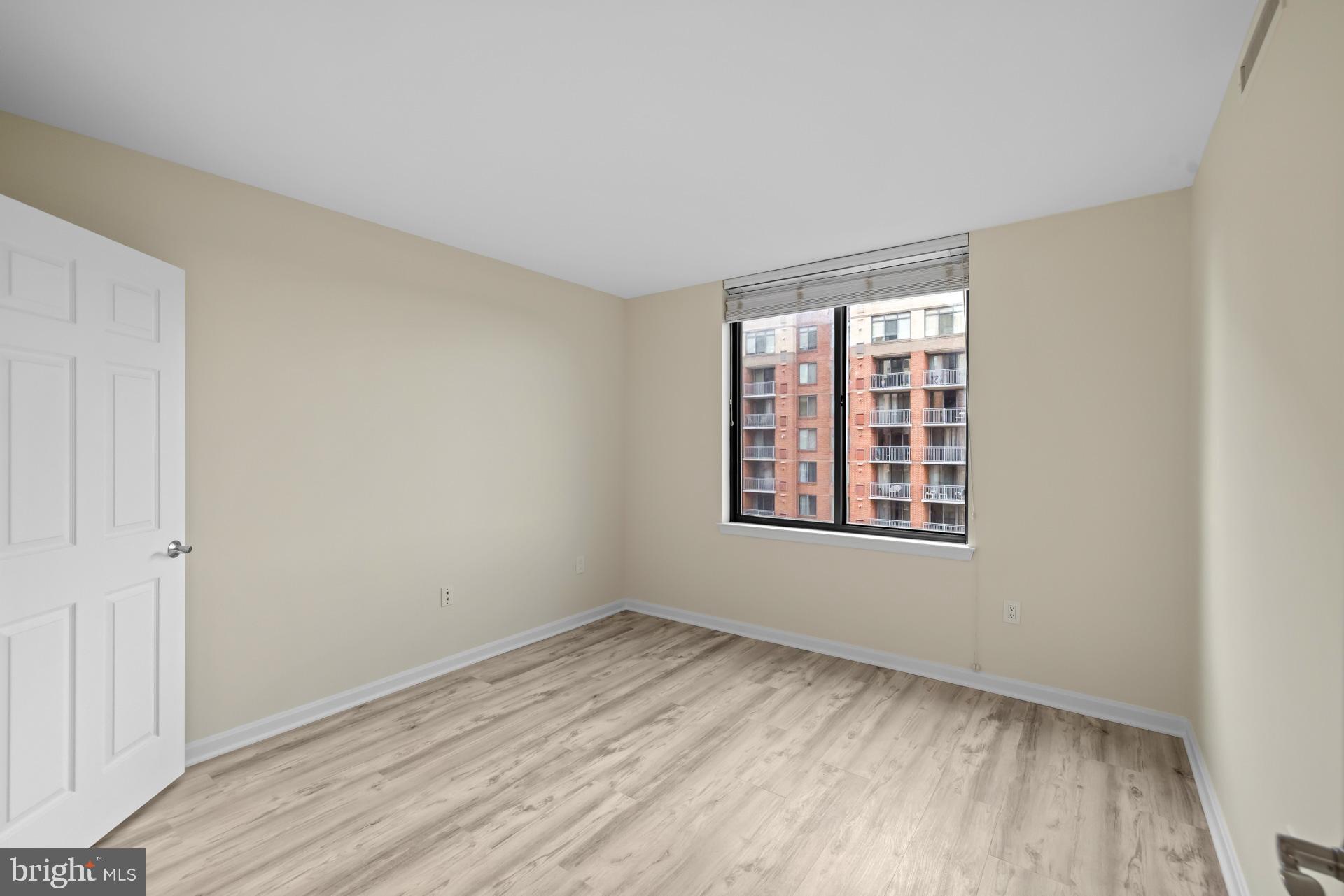 11710 Old Georgetown Road, Unit 1116W North Bethesda, MD 20852 - Photo 17 of 52 an empty room with wooden floor and windows