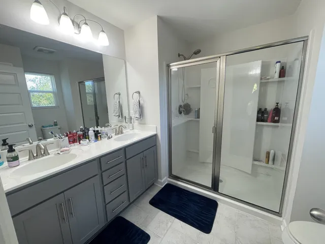 a bathroom with a shower sink and mirror