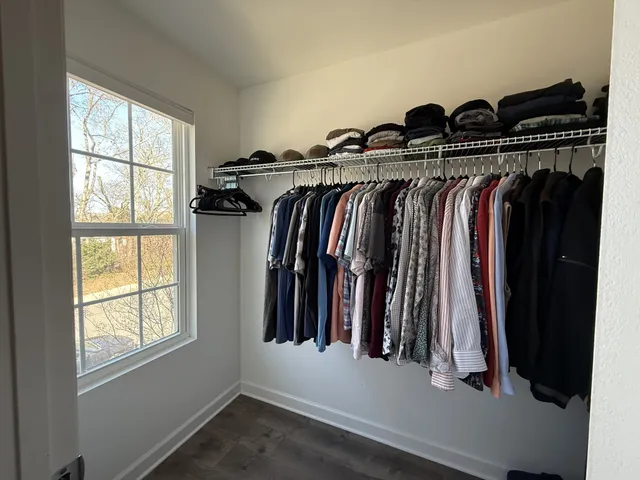 a view of walk in closet with clothes and shoes