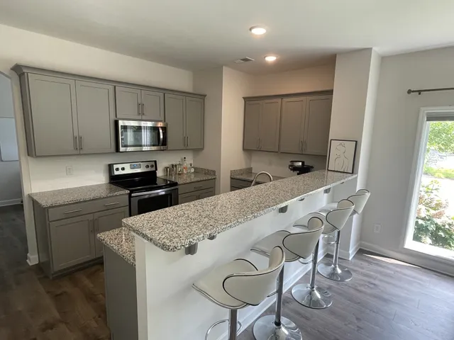 a kitchen with kitchen island white cabinets and stainless steel appliances