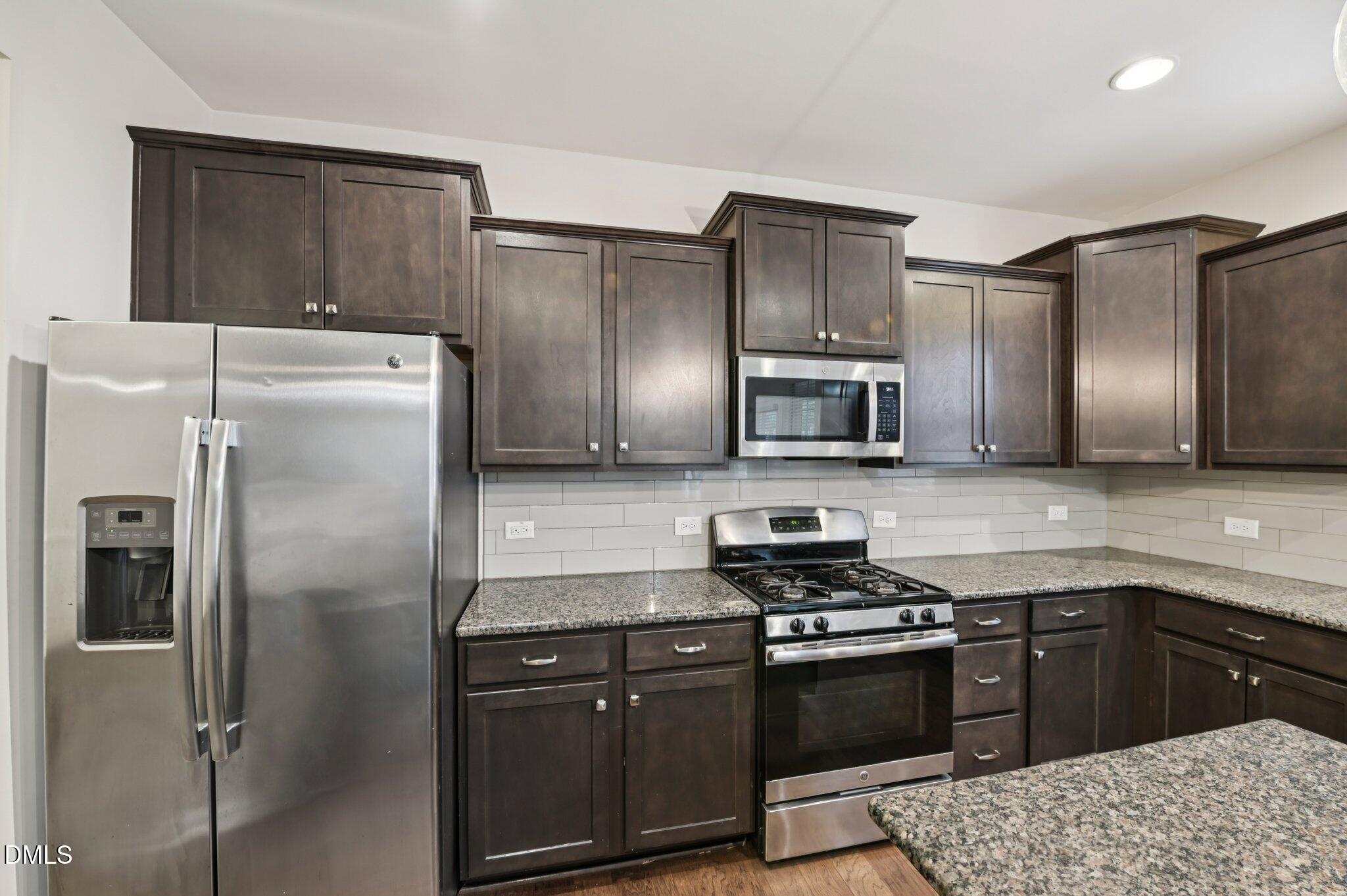 1024 Laredo Lane Durham, NC 27703 - Photo 12 of 32 a kitchen with stainless steel appliances granite countertop a refrigerator and a stove top oven
