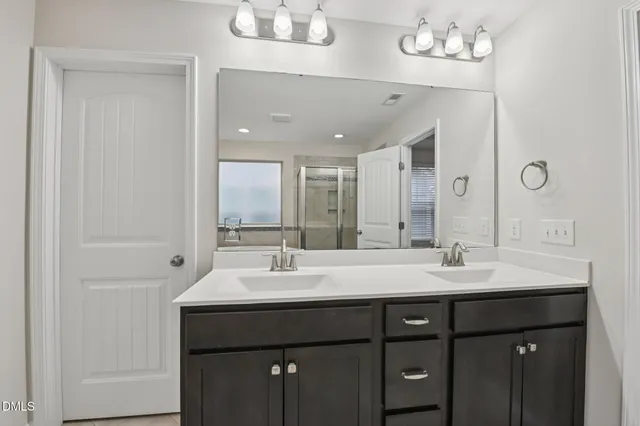 a bathroom with a double vanity sink and a mirror