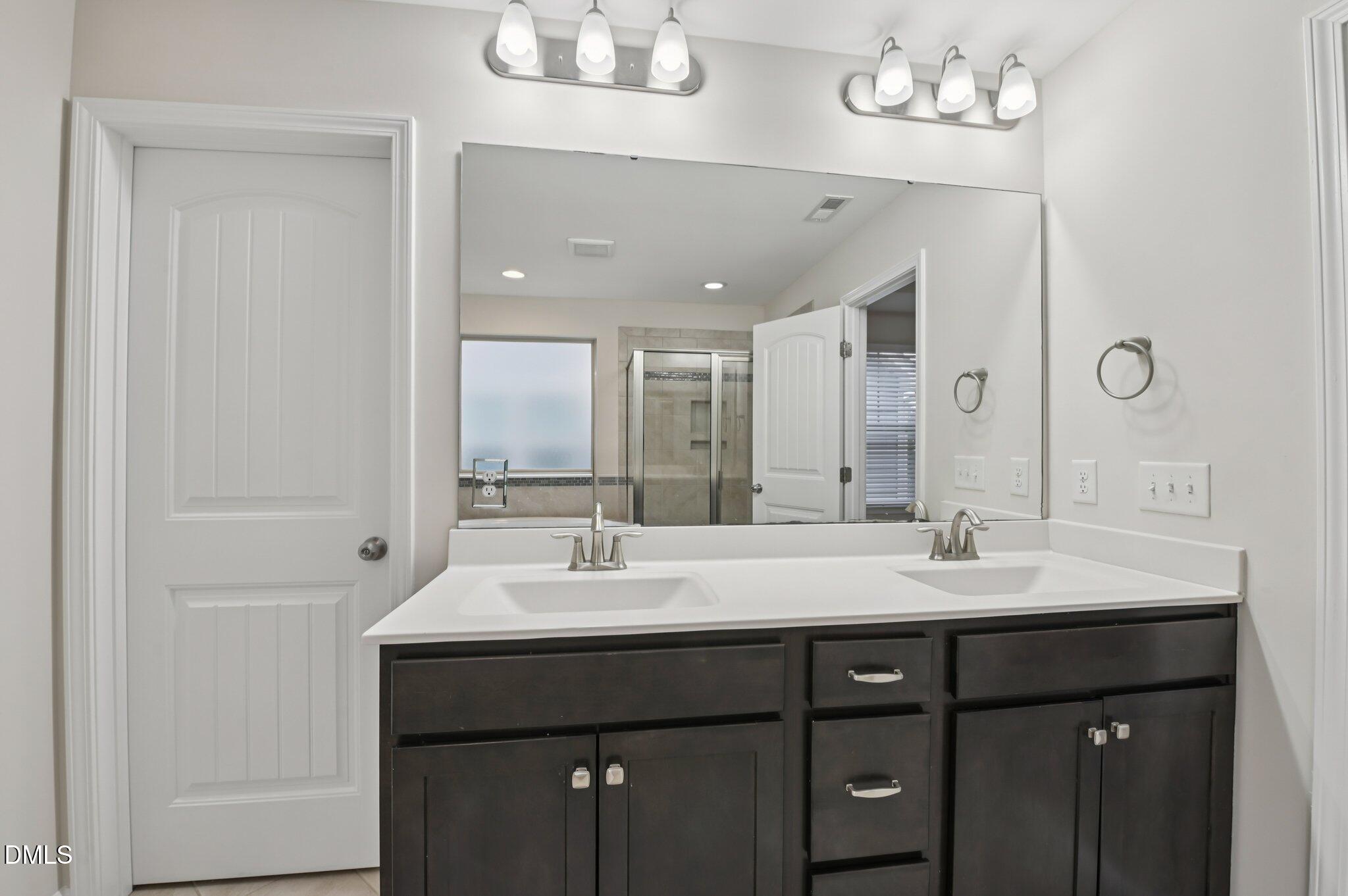 1024 Laredo Lane Durham, NC 27703 - Photo 21 of 32 a bathroom with a double vanity sink and a mirror