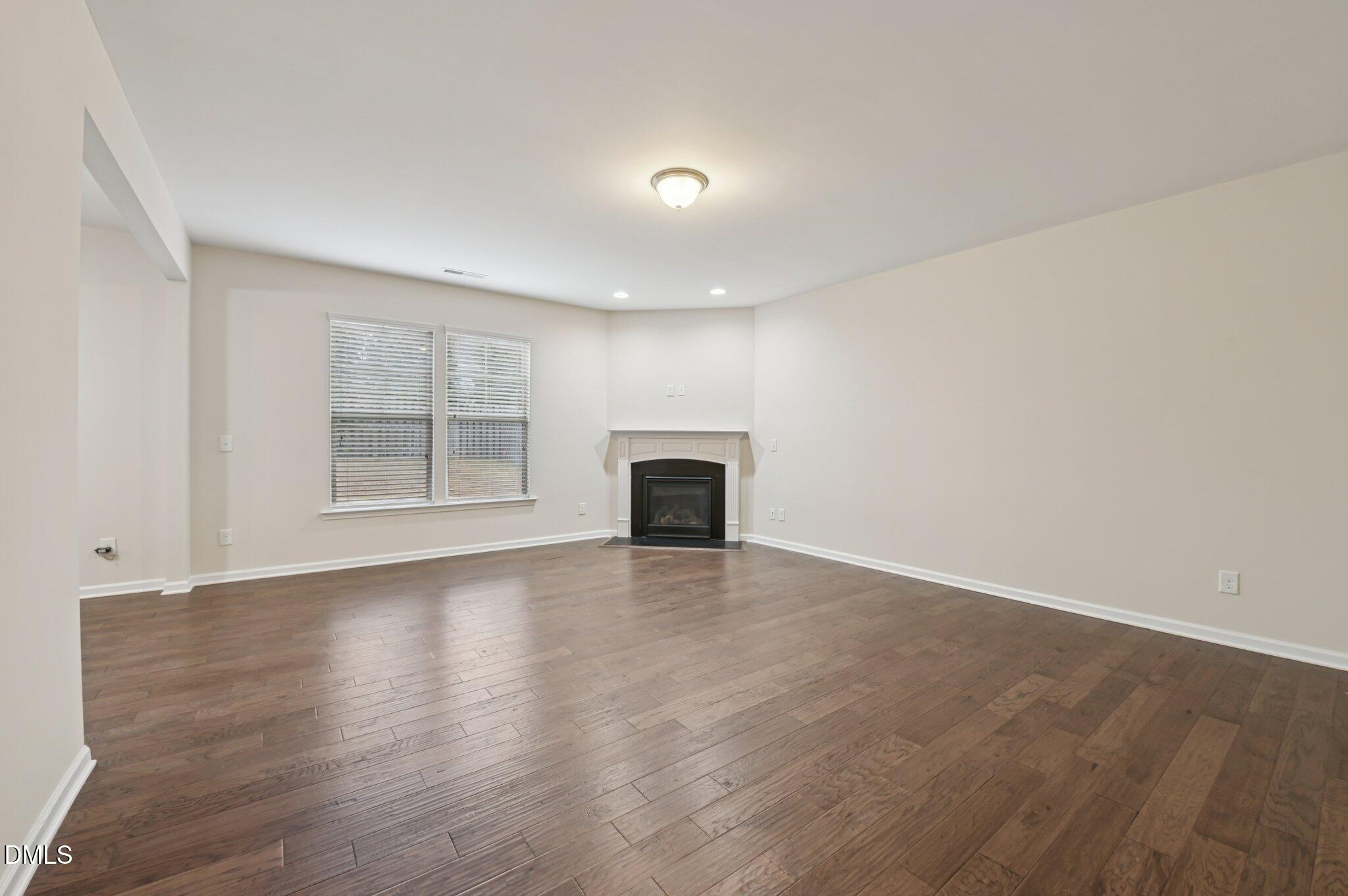 1024 Laredo Lane Durham, NC 27703 - Photo 7 of 32 an empty room with wooden floor and fireplace