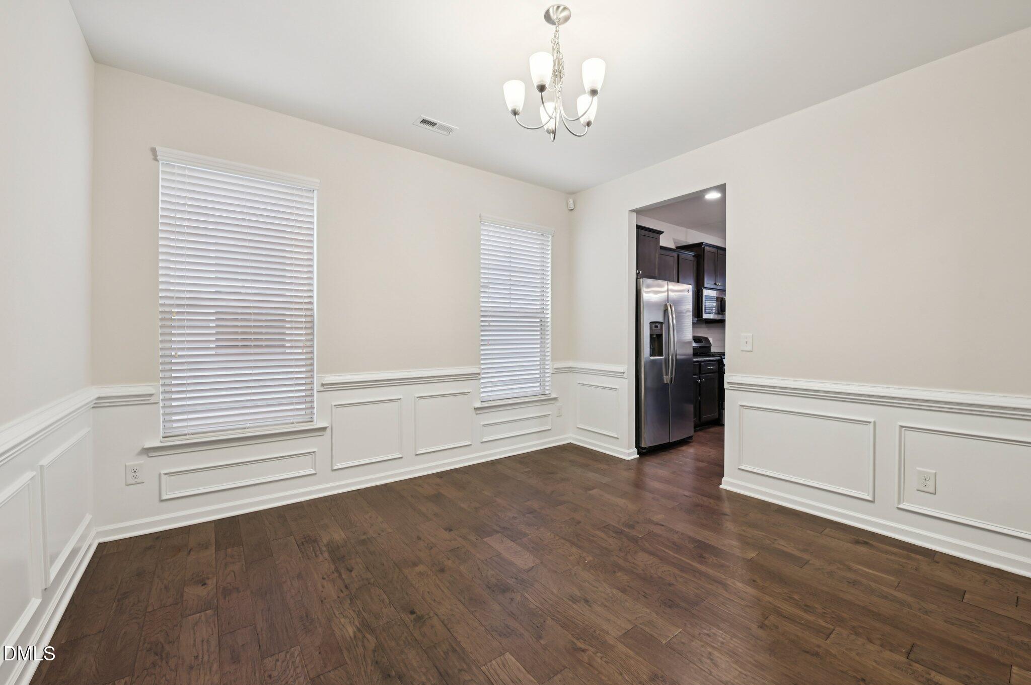 1024 Laredo Lane Durham, NC 27703 - Photo 8 of 32 an empty room with wooden floor and windows