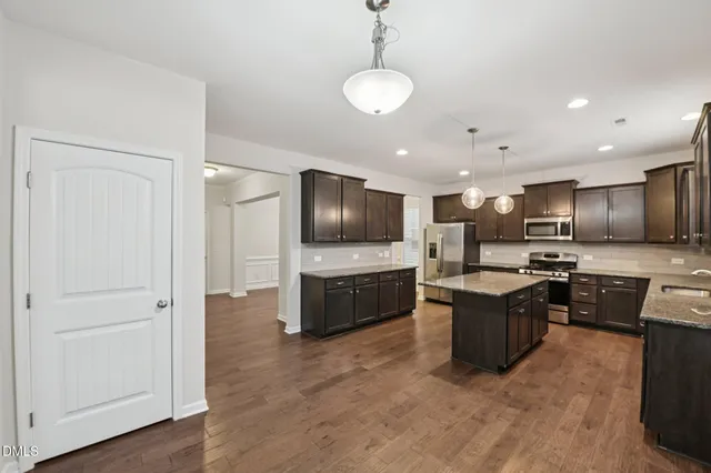 a living room with furniture kitchen view and a flat screen tv