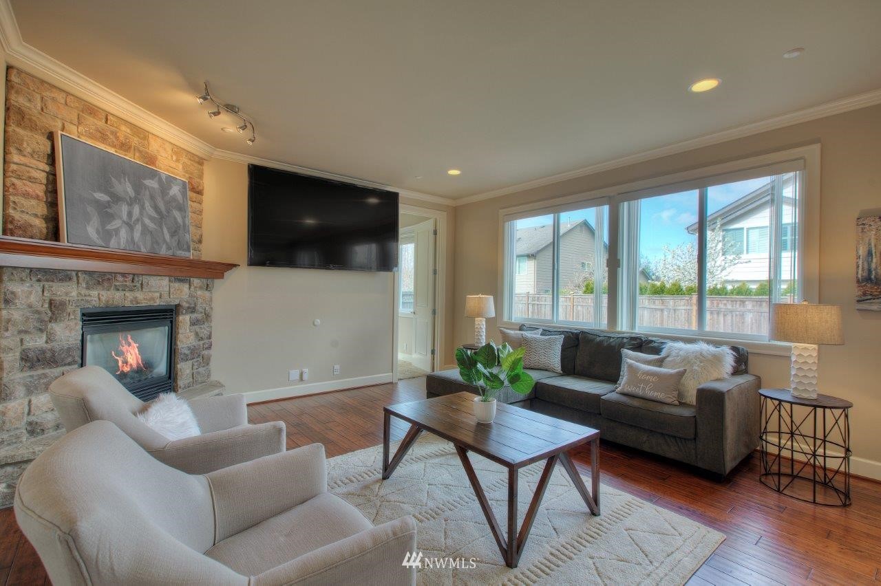 123 Ilwaco Place Southeast Renton, WA 98059 - Photo 13 of 33 a living room with furniture a flat screen tv and a fireplace
