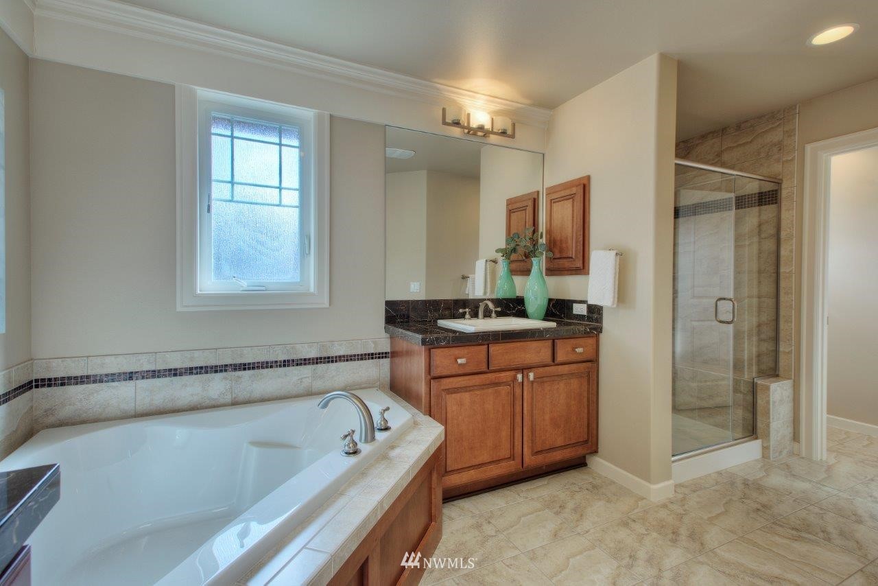 123 Ilwaco Place Southeast Renton, WA 98059 - Photo 24 of 33 a bathroom with a tub sink and mirror