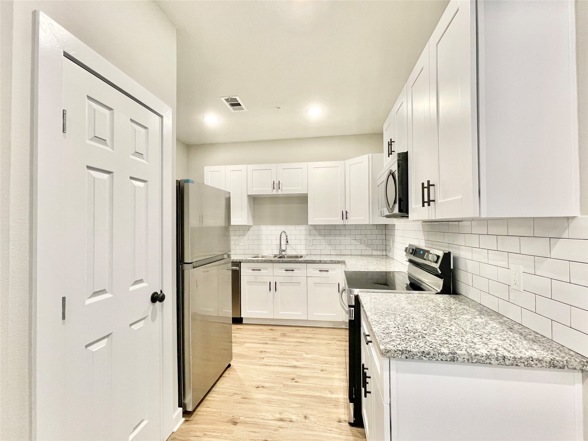 10317 Lake Road, Unit 4A Houston, TX 77070 - Photo 6 of 14 a kitchen with stainless steel appliances granite countertop a refrigerator and a sink