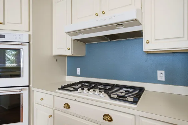 a stove top oven sitting inside of a kitchen