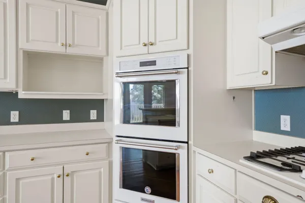 a kitchen with white cabinets and stainless steel appliances