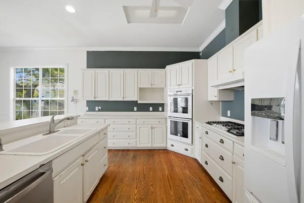 a kitchen with granite countertop a sink stainless steel appliances and cabinets
