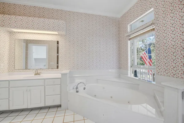 a bathroom with a bathtub sink and mirror