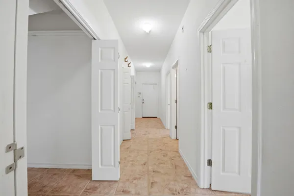 a view of a hallway with wooden floor and closet