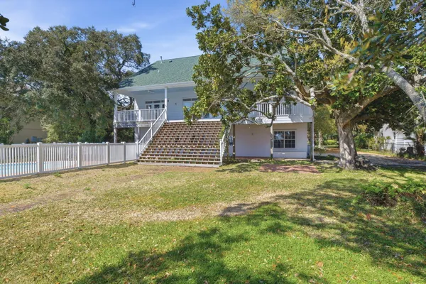 a front view of a house with a garden and trees