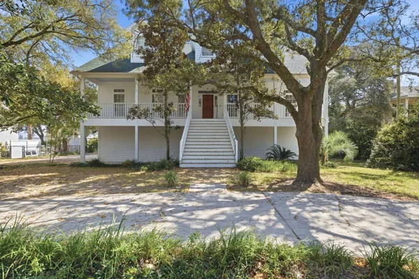 a view of a house with a yard and large tree