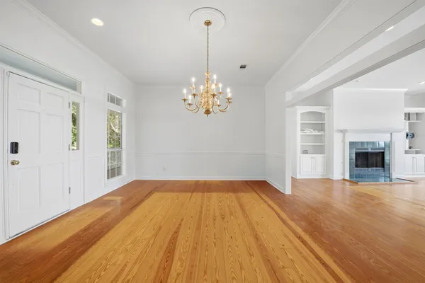 a view of empty room with wooden floor and fireplace