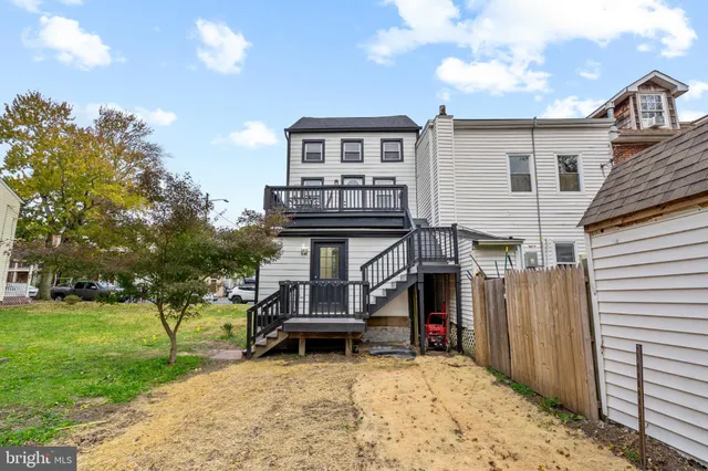 a view of a house with a wooden deck and furniture