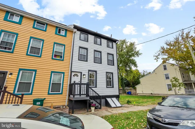 a view of a patio with couches and table and chairs and potted plants