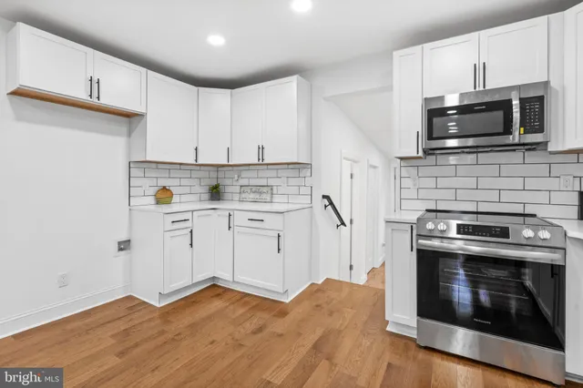 a kitchen with stainless steel appliances a stove a microwave sink and cabinets