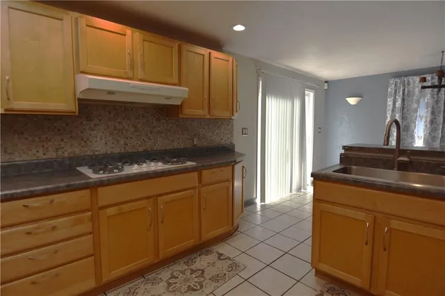 a kitchen with granite countertop cabinets stainless steel appliances and a counter space