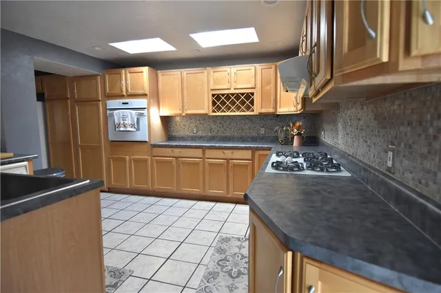 a kitchen with stainless steel appliances granite countertop a sink stove and cabinets
