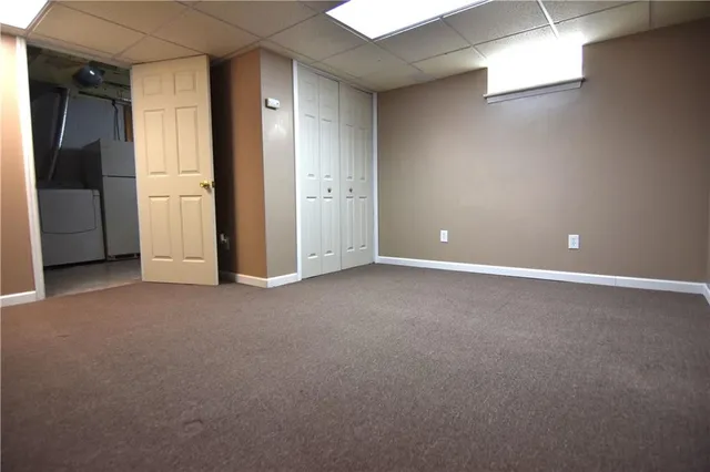 a room with water heater and wooden cabinets