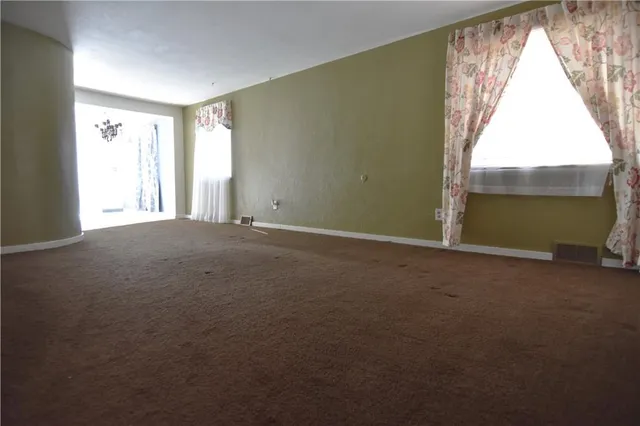 a view of a livingroom with an empty space and a window
