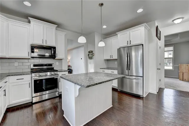 a spacious bedroom with a large bed and a chandelier fan