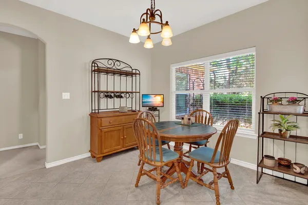 a dining room with furniture a chandelier and window
