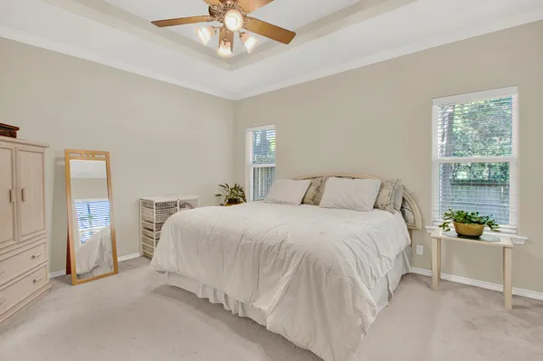 a bedroom with a large bed and a chandelier