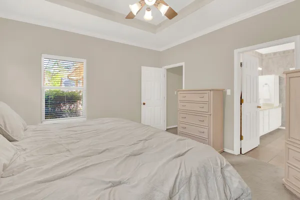 a bedroom with a bed a chandelier and a window
