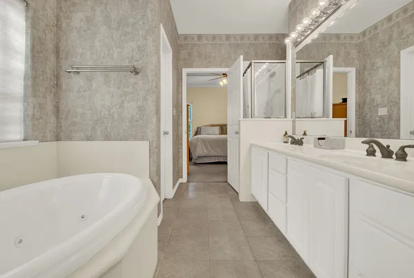 a bathroom with a tub sink and mirror
