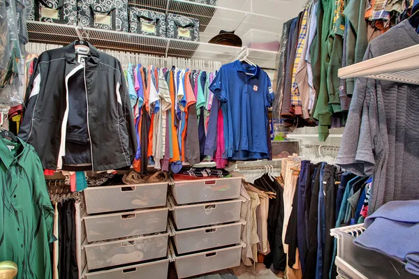 a view of walk in closet with clothes and shoes