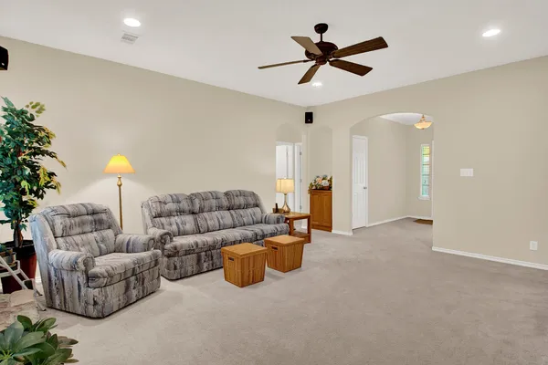 a living room with furniture and a ceiling fan