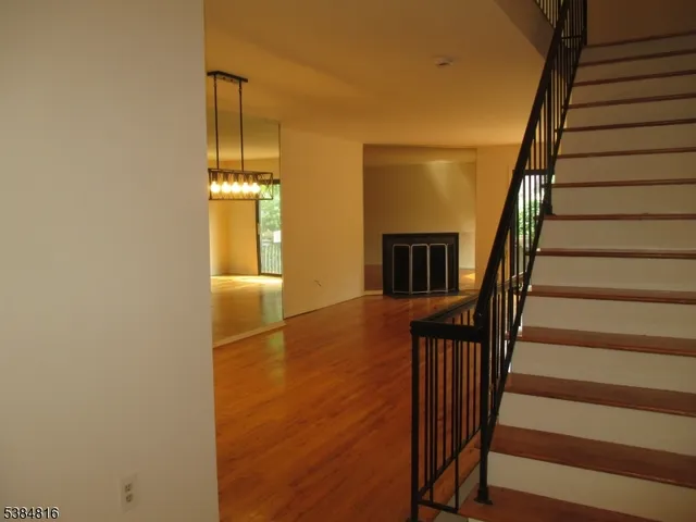a view of a hallway with wooden floor and staircase